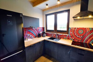 A modern kitchen with a Samsung refrigerator, a window with a view, and colorful patterned backsplash tiles. - Holiday House, Sauna, Whirlpool, Mielenko (Mielno)