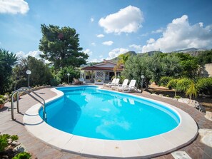 A swimming pool with a sun terrace and lounge chairs, surrounded by trees and a mountain in the background. - Villa in Castellammare del Golfo With Private Pool (Castellammare del Golfo)