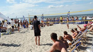 A beach volleyball game with spectators on the sand and chairs. - Holiday Homes for 7 People in Swinoujscie (Swinoujscie)