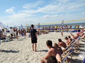A beach volleyball game with spectators on the sand and chairs. - Holiday Homes for 7 People in Swinoujscie (Swinoujscie)