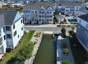Un área residencial con un estrecho canal, casas con balcones y cielo despejado.