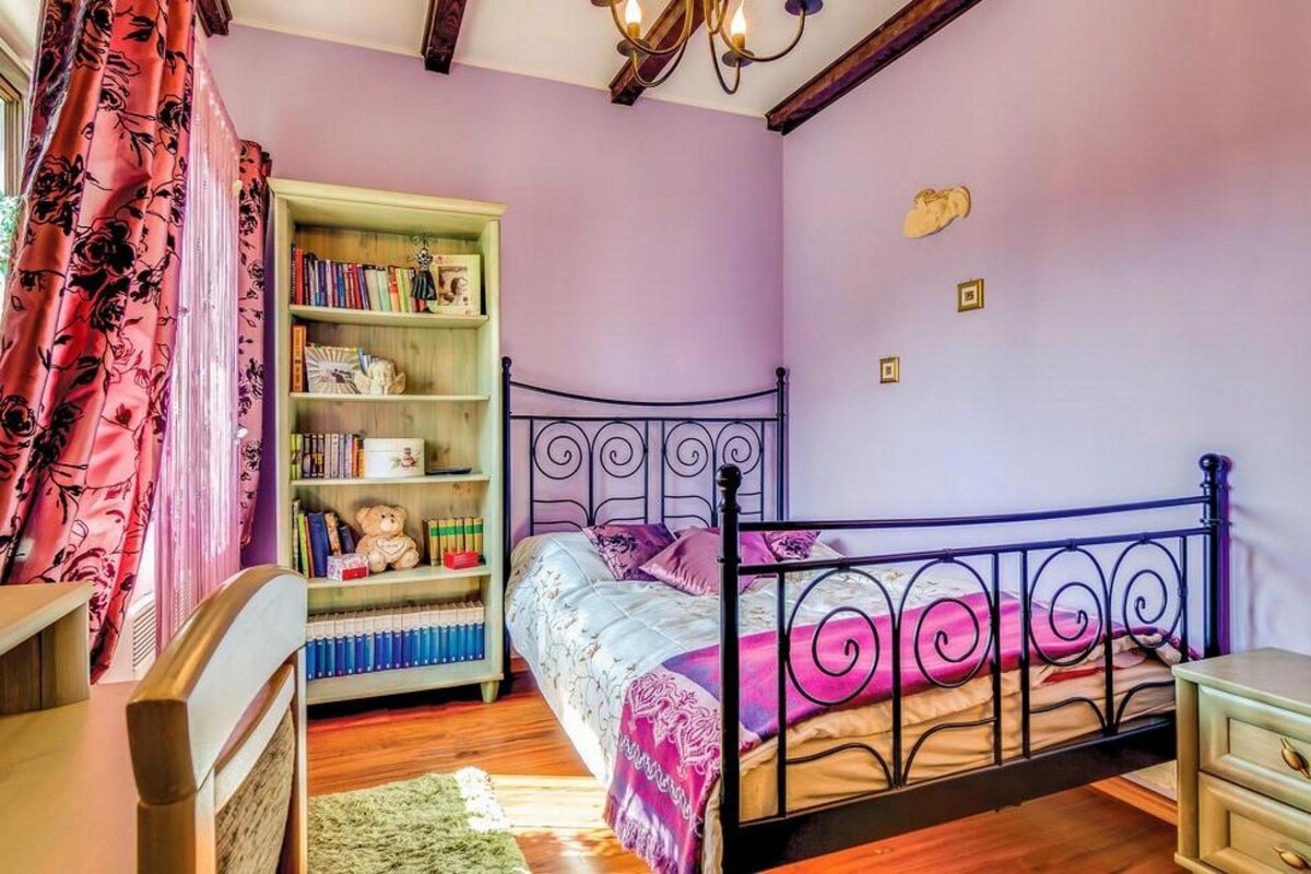 Ein Schlafzimmer mit einem Bett, einem Bücherregal, einem Schreibtisch und einem Stuhl.