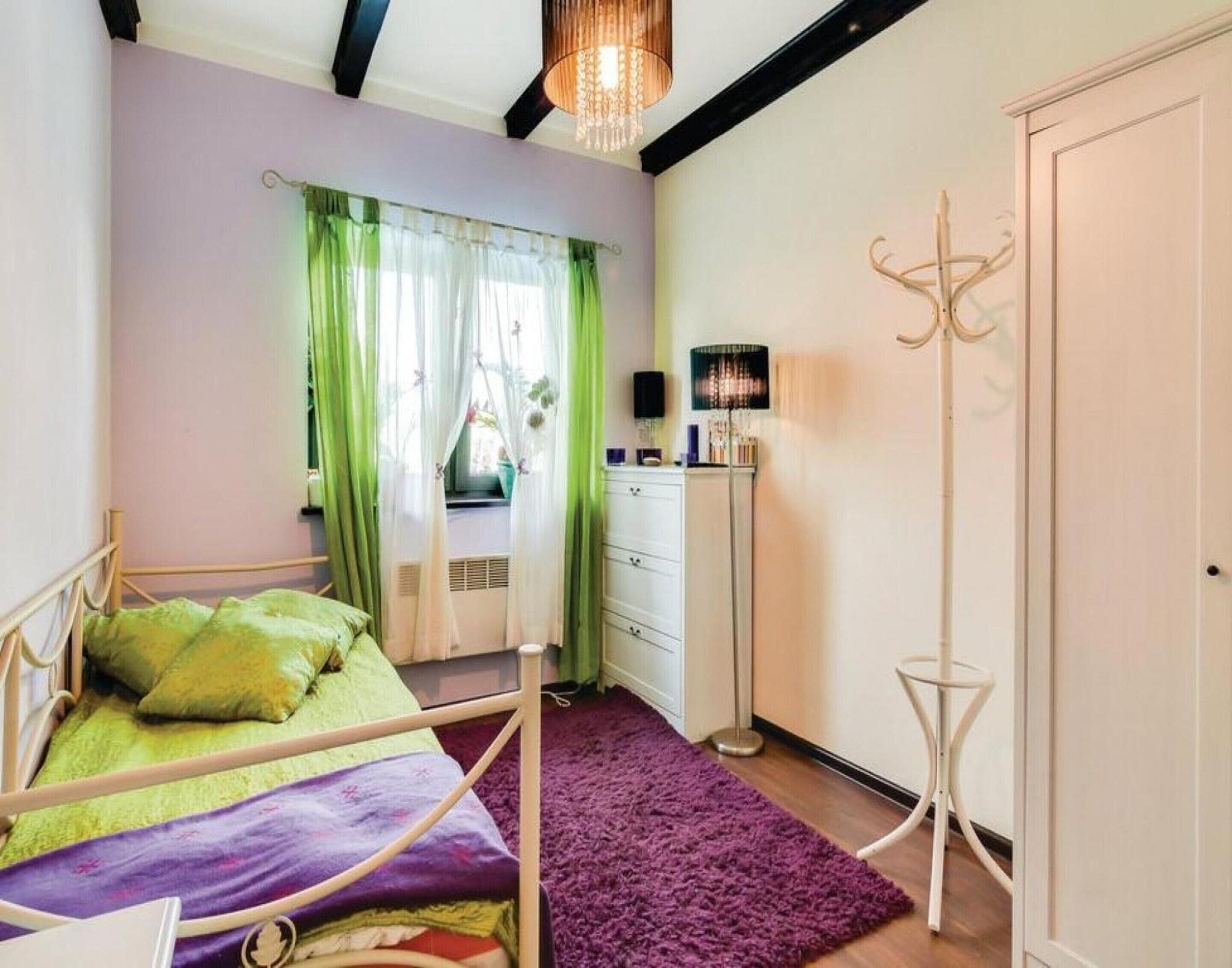 Quarto com cama, penteadeira, guarda-roupa e luminária de chão.