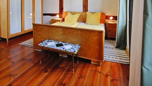 Un dormitorio con cama de madera, una mesita de noche y un armario.