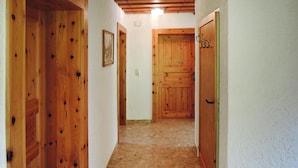 A narrow hallway with wooden doors and a framed picture on the wall. - Apartment in Fusch an der Glocknerstrasse in Nature (Fusch an der Grossglocknerstrasse)
