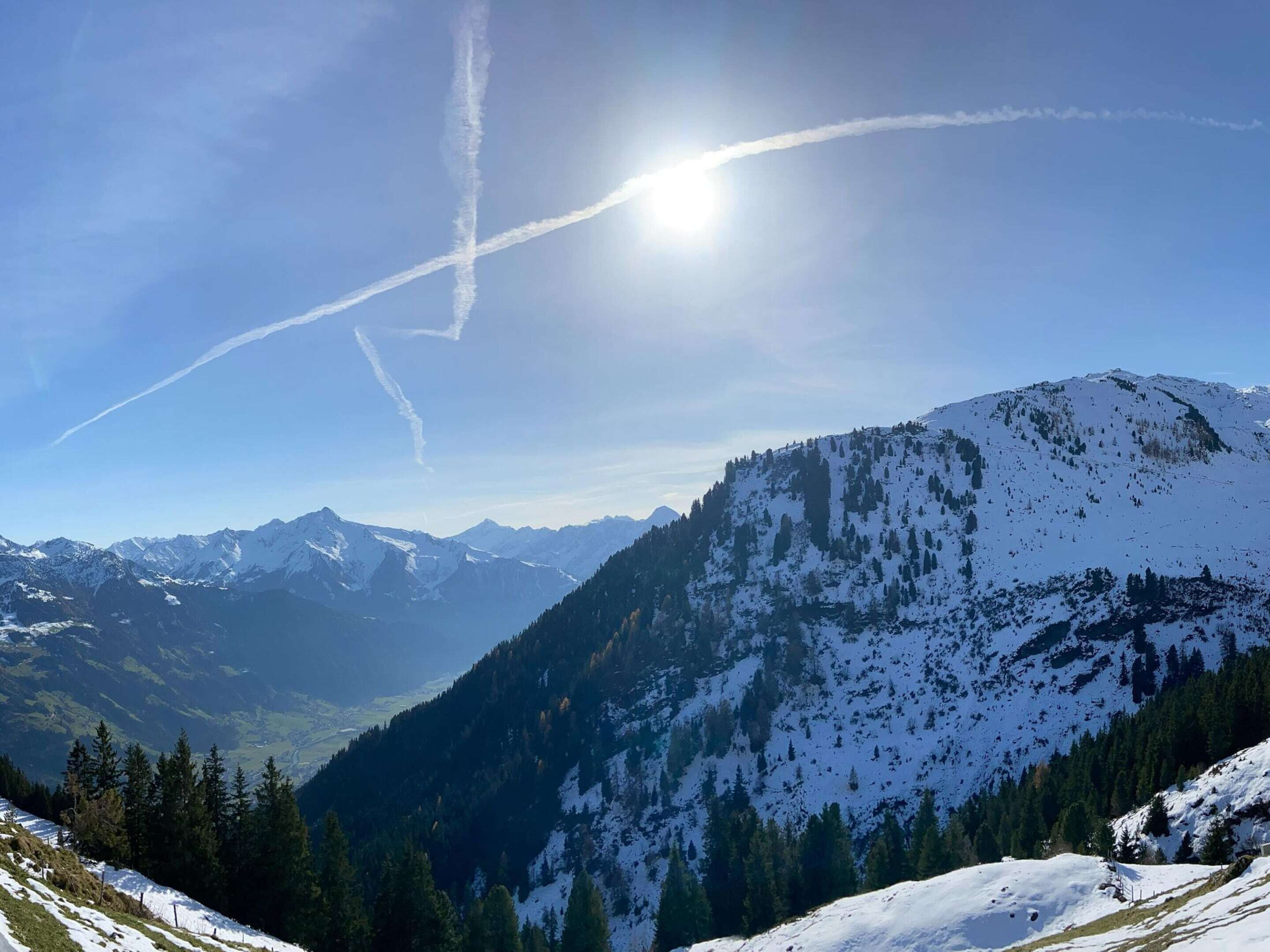 A mountainous landscape with snow-covered peaks and a clear sky.