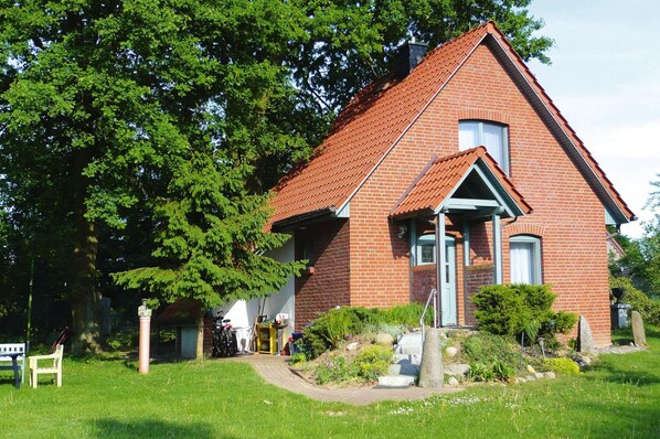 A red brick house with a sloped roof, a front porch, and a small garden. - Holiday Home, Plau am See (Plau am See)