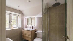 Un baño moderno con bañera, inodoro y cabina de ducha de vidrio.
