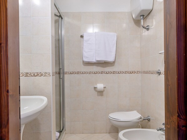 A bathroom with a shower, toilet, and sink.
