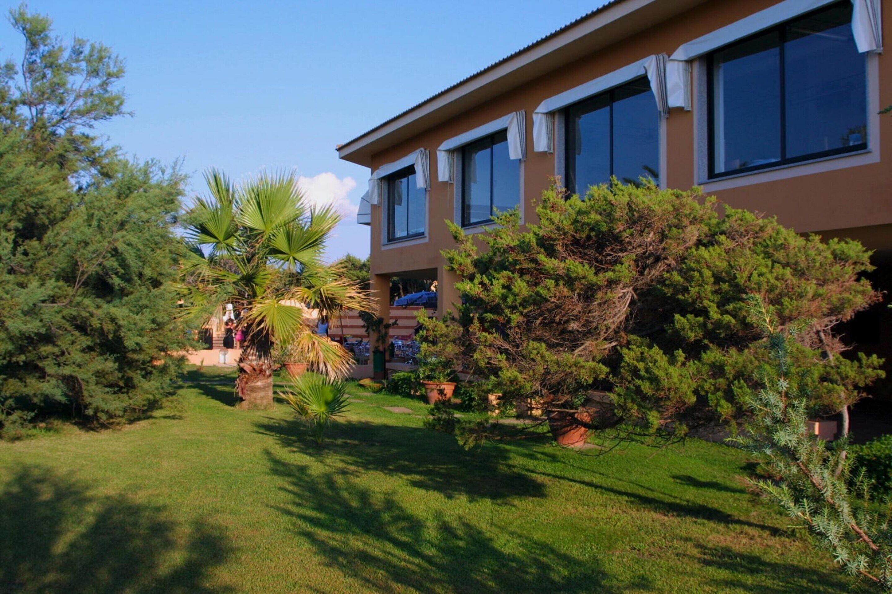 A two-story building with a well-maintained garden in front.