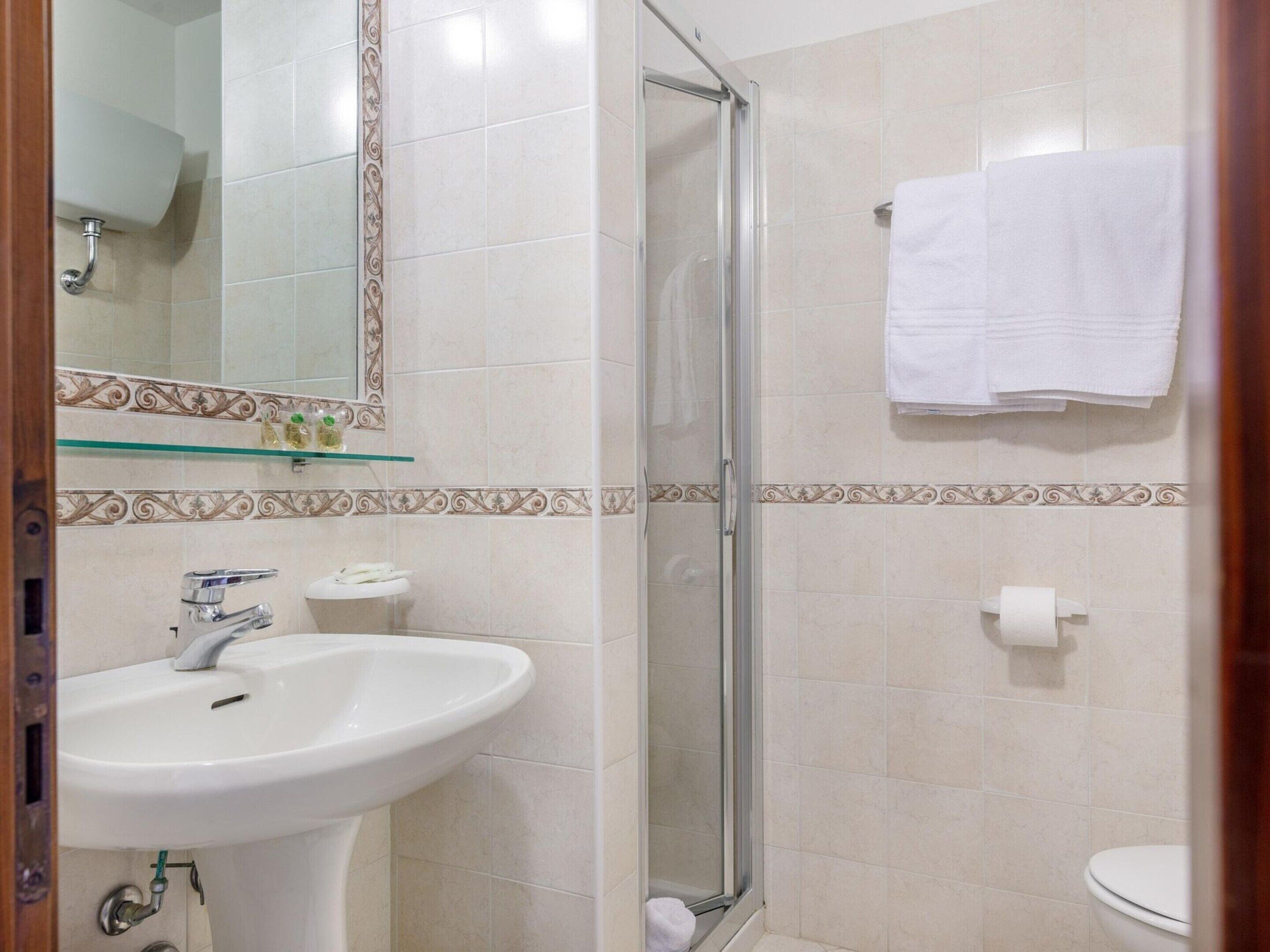 A bathroom with a sink, toilet, and shower.