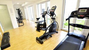 Een sportschool met loopbanden, hometrainers en krachttoestellen.