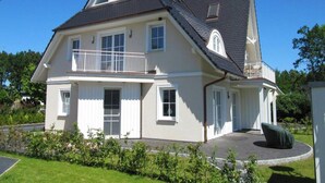 A two-story house with a balcony, a chimney, and a well-maintained lawn. - Apartment, Zingst (Zingst)