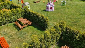 A spacious outdoor area with a playground, picnic tables, and small playhouses. - Cozy Holiday Homes Near the Beach in Jaroslawiec (Postomino)