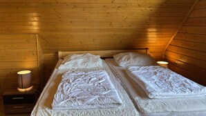 A small, cozy room with a wooden sloped ceiling and two single beds with white bedding. - Blockhaus, Bad Sachsa (Bad Sachsa)