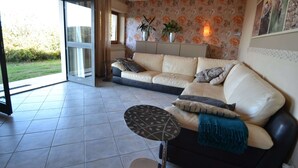 A living room with a sofa, a coffee table, and a view of the outdoors. - Spectacular Holiday Home in Pescia With Swimming Pool (Pescia)