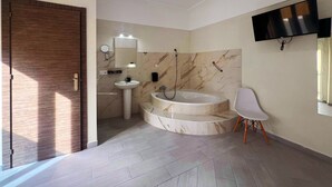A modern bathroom with a vanity, sink, and bathtub. - Hostal Pompeya (Merida)