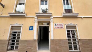 A building with a sign reading "Hostal Pompeya" and a blue 'H' sign indicating a hotel. - Hostal Pompeya (Merida)