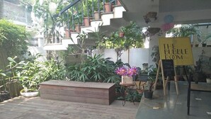 Une terrasse en bois agrémentée de plantes en pot, d’un banc et d’une pancarte indiquant : « THE BUBBLE ROOM ».