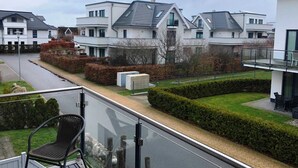 Un quartier résidentiel avec des maisons modernes, une route asphaltée et une pelouse bien entretenue.