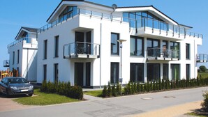 A modern two-story building with balconies, large windows, and a car parked in front. - Apartment House Calmsailing, Borgerende (Boergerende-Rethwisch)