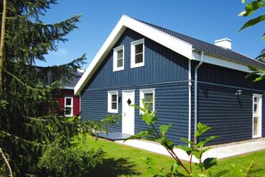 A two-story house with a dark blue exterior, white trim, and a sloped roof. - Holiday Home Seeidyll am Dummer See, Dummer (Dummer)