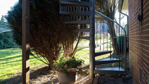 A spiral staircase leading to a covered outdoor area with a potted plant at the base. - Comfortable Holiday Apartment in St. Peter Ording (St. Peter-Ording)