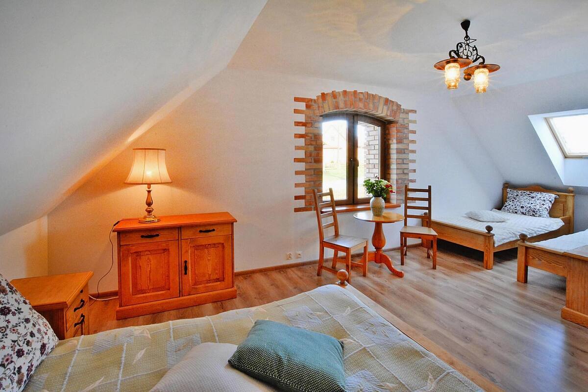 A cozy attic bedroom with a bed, a desk, and a chair.