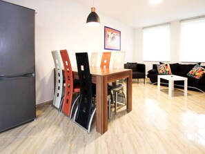A modern living room with a dining area, a black sofa, a white table, and a colorful couch. - Terraced House, Lohmen (Lohmen)
