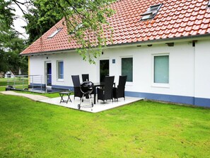 A house with a red-tiled roof, a covered patio with a grill, and a small pool. - Terraced House, Lohmen (Lohmen)