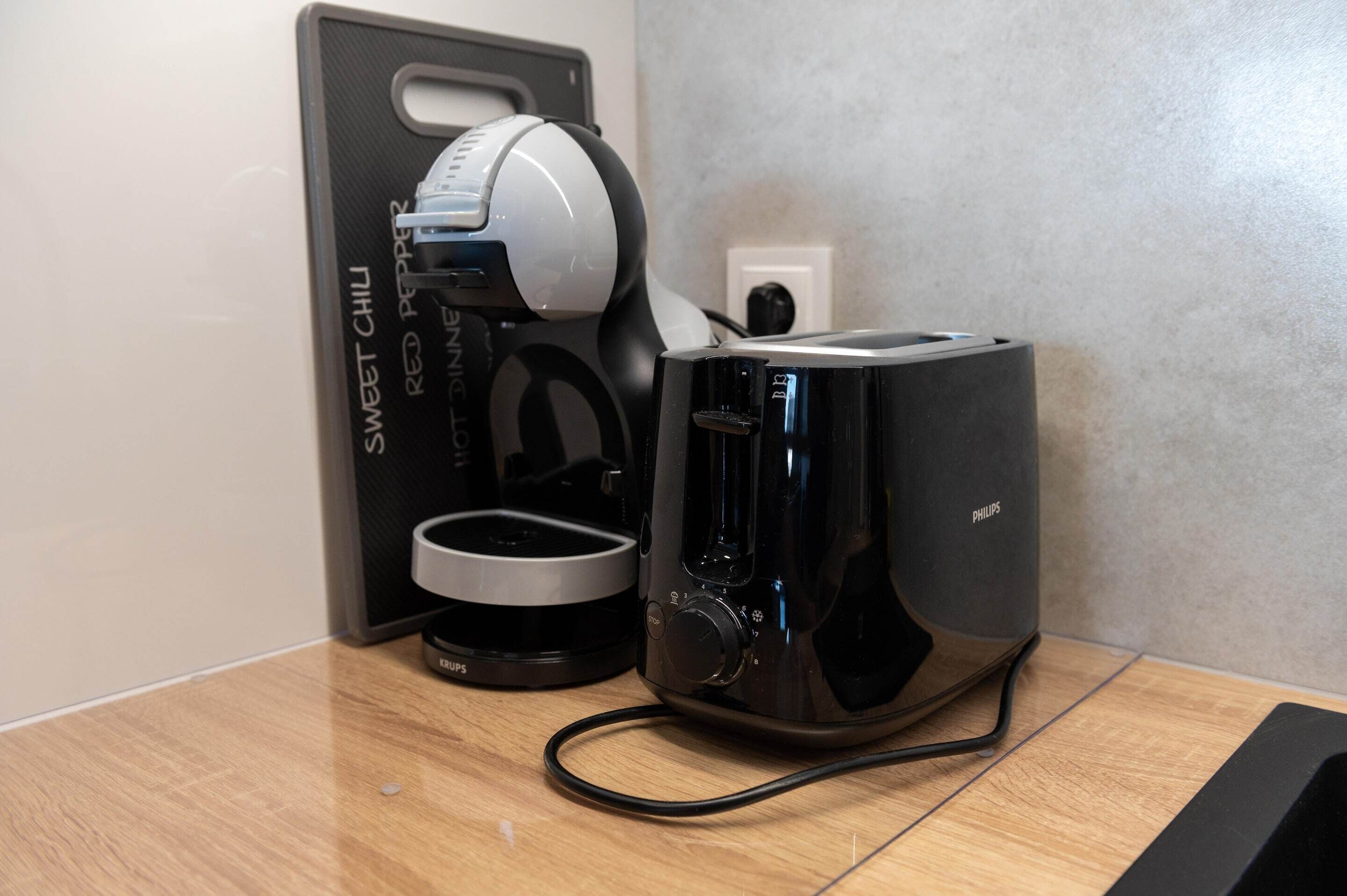 Een Philips broodrooster en een koffiezetapparaat op een houten aanrecht.