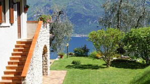 A stone staircase leading to a white building with a view of a lake and mountains. - Apartments Casa Tamas, Limone (Tremosine)