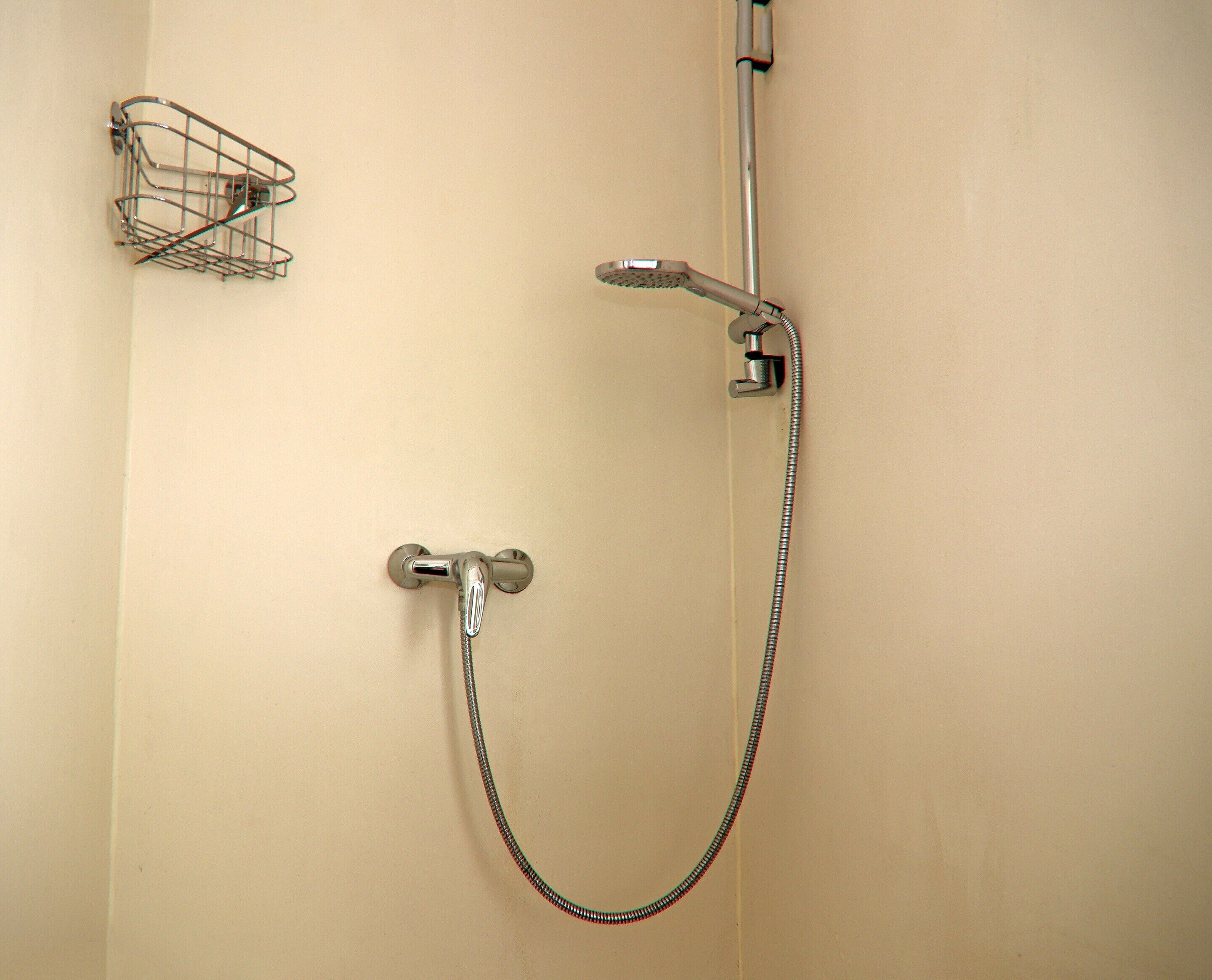 A shower with a handheld showerhead and a flexible hose.