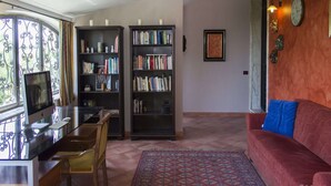 A living room with a red sofa, a coffee table, a TV, two bookshelves, and a patterned rug. - Lovely Villa in Castellammare del Golfo With Private Pool (Castellammare del Golfo)