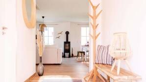 A modern living room with a sofa, a wooden bench, a lamp, and a fireplace. - Holiday Home With Sauna in Boiensdorf (Boiensdorf)