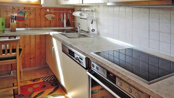 A kitchen with wooden cabinets, a dishwasher, a stove, and a tiled backsplash.