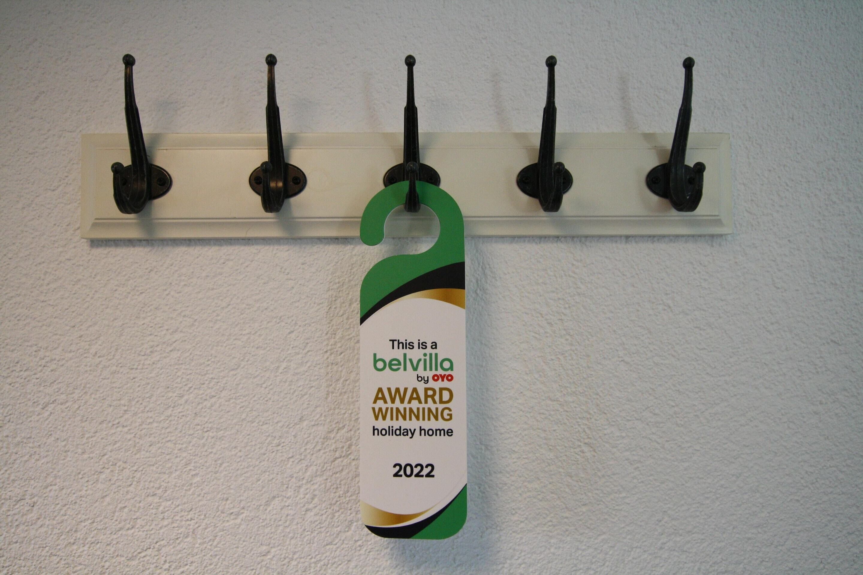 A wall-mounted hook with a tag indicating a 2022 award for a holiday home.