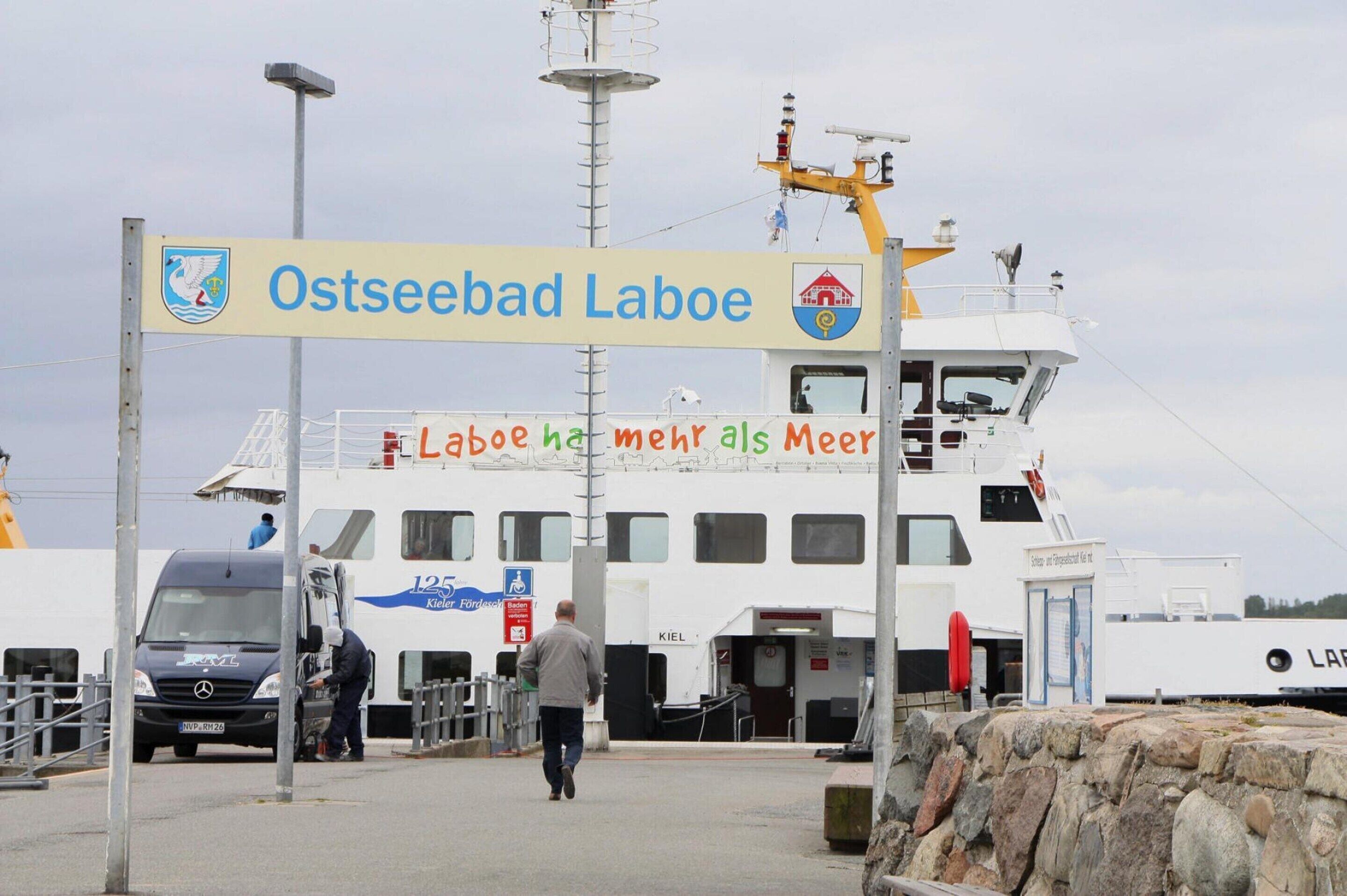 Terminal de ferry con un cartel que dice 'Ostseebad Laboe' y un ferry atracado en el muelle.