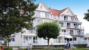 Een hotel met meerdere verdiepingen, балконы, een centrale binnenplaats en een verzorgde tuin.