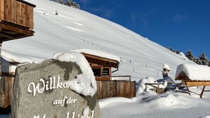 A stone sign with the text "Willkommen auf der Hirschbichl Alm 1840m" indicating a welcome to the Hirschbichl Alm at an elevation of 1840 meters. - Unique Large Alpine Pasture in the Middle of the Zillertal Mountains (Zellberg)