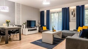 Una sala de estar moderna con comedor, televisor de pantalla plana y sofá.