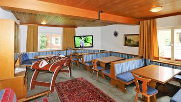 A cozy room with wooden furniture, a foosball table, and a television.