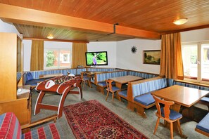 A cozy room with wooden furniture, a foosball table, and a television. - Holiday Home Bergheim, Fugen (Fuegen)
