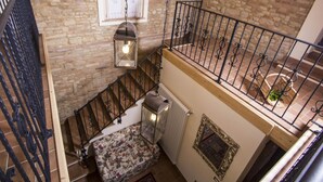A staircase with a wrought iron railing, a radiator, and a floral-patterned bench. - Belvilla by OYO Villa Vanessa Coccinella (Fano)