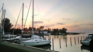 A marina with several sailboats docked, calm water, and a sunset in the background. - Holiday Home Haffschein, Monkebude (Monkebude)