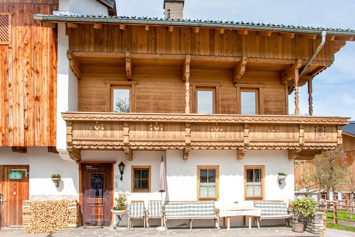 A wooden building with a balcony, a stone wall, and a sign indicating a room number.