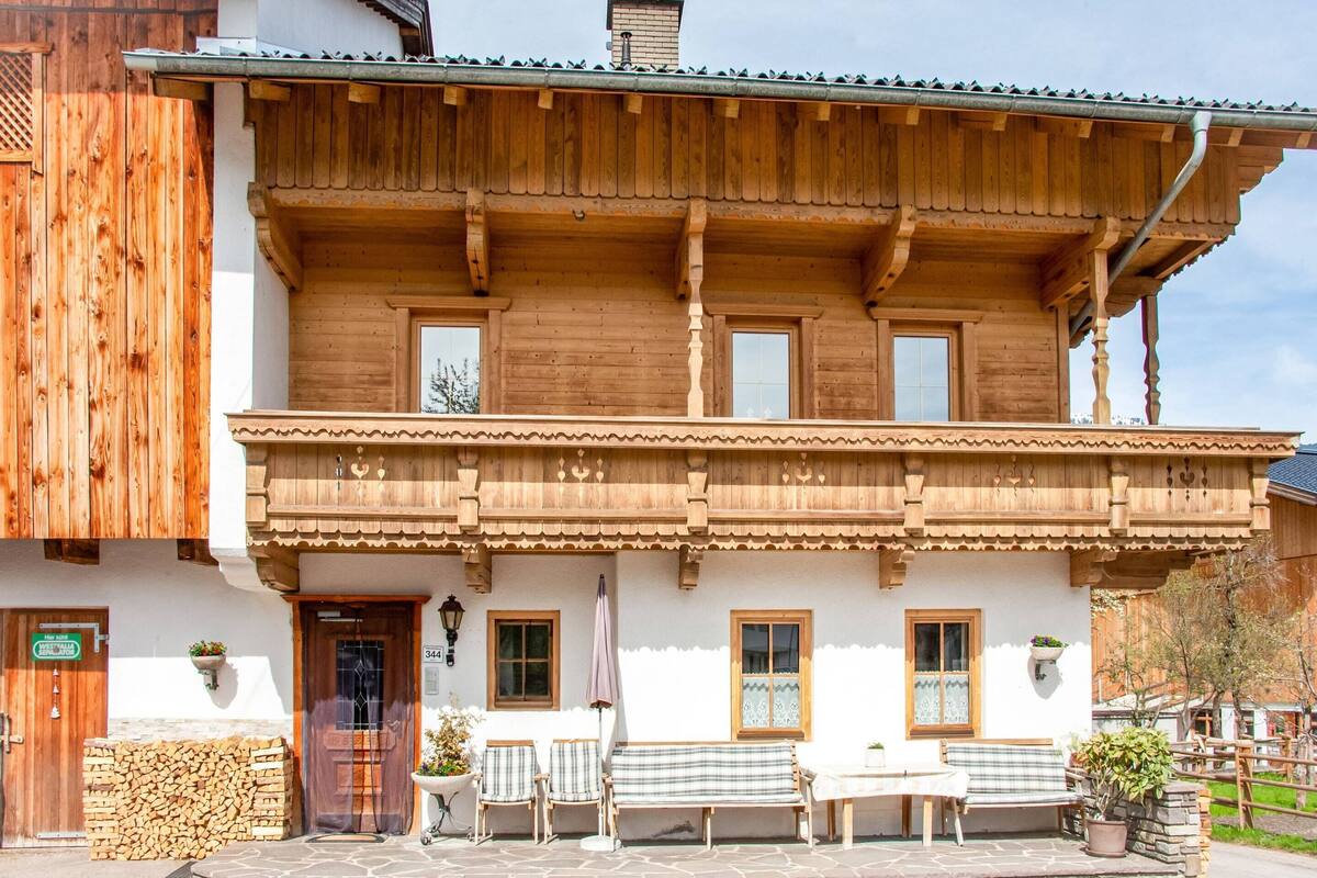 A wooden building with a balcony, a stone wall, and a sign indicating a room number.