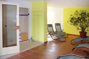 A room with a shower, two striped lounge chairs, a potted plant, and a yellow wall. - Semi-detached House, Kuehlungsborn (Kuehlungsborn)