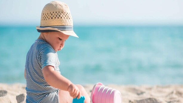 A child playing with toys on a sandy beach with a clear blue sky and ocean in the background. - Comfy Apartment Near the sea in Gaski (Mielno)
