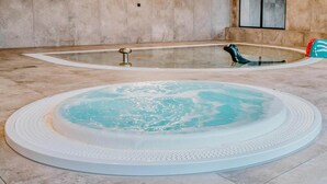 Ein Wellnessbereich mit Whirlpool und eigenem Pool.